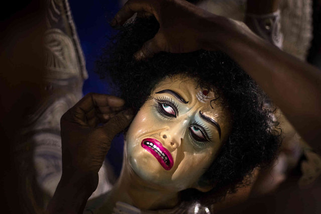 An artisan works on the hair of the face of a demon while giving finishing touches to clay images of Hindu goddess Durga in a studio ahead of Durga Puja festival in Gauhati, India, Saturday, October 9, 2021. After worship the idols will be immersed in water bodies at the end of the festival. (Photo by Anupam Nath/AP Photo)