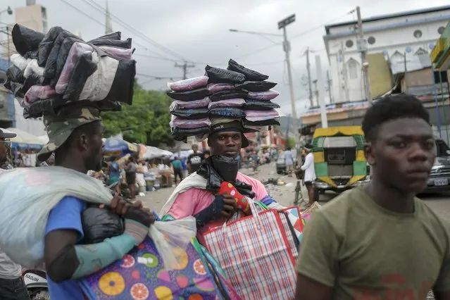 Street vendors hawking plastic bags wait for customers during the general strike in Port-au-Prince, Haiti, Monday, October 18, 2021. (Photo by Matias Delacroix/AP Photo)