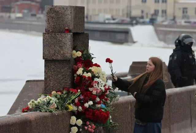A woman lays flowers at the monument to the victims of political repressions to honour the memory of Russian opposition leader Alexei Navalny, in Saint Petersburg, Russia on February 17, 2024. (Photo by Reuters/Stringer)