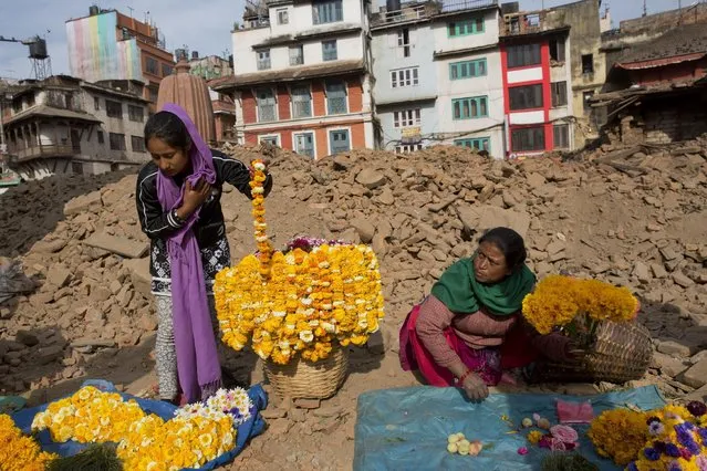 Nepalese flower vendors wait for customers at the Basantapur Durbar Square, damaged in the April 25 earthquake in Kathmandu, Nepal, Tuesday, May 5, 2015. (Photo by Bernat Amangue/AP Photo)