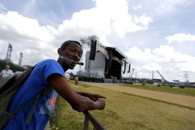 A man smokes as the stage to be used for the Rolling Stones' free outdoor concert on March 25 is seen at Ciudad Deportiva de la Habana sports complex, Havana, March 19, 2016. (Photo by Ivan Alvarado/Reuters)