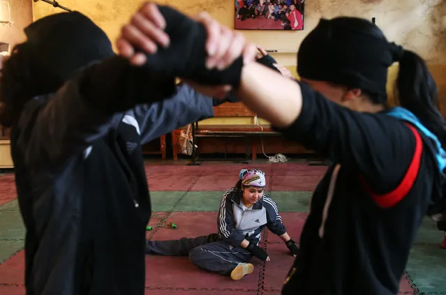 In this Wednesday, March, 5, 2014 photo, Afghan female boxers exercise during a practice session at the Kabul Stadium boxing club, Afghanistan. The women, who are 18 and older, don't have much more than determination, and a trainer who runs them through their paces, watches as they spar, corrects their technique, tells them when to jab, how to protect themselves, when to power through with a left and then a right. (Photo by Massoud Hossaini/AP Photo)