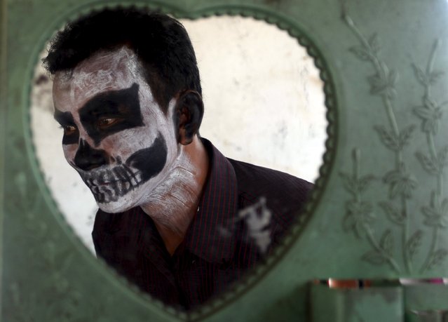 A villager paints his face during the annual “Lok Ta Pring Ka-Ek” religious ceremony, on the outskirts of Phnom Penh May 22, 2015. (Photo by Samrang Pring/Reuters)