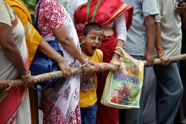 A boy yawns as he and others hold a rope to pull a “Rath”, or the chariot of Lord Jagannath, to seek blessings on the last day of the week-long celebration of Lord Jagannath's “Rath Yatra”, or the chariot procession, in Kolkata, India, July 12, 2019. (Photo by Rupak De Chowdhuri/Reuters)