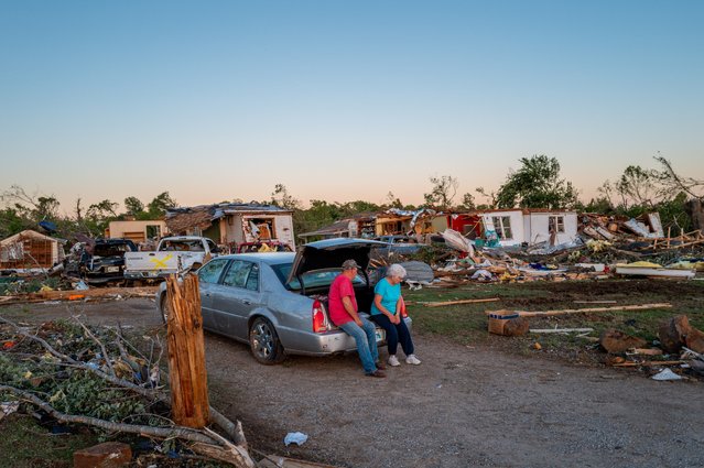 The Millers sit together in the trunk of their car amid their neighborhood levelled by a tornado on May 07, 2024 in Barnsdall, northeast Oklahoma. The EF3 twister that struck claimed one life and destroyed dozens of homes in the community of just over 1,000 people. (Photo by Brandon Bell/Getty Images)