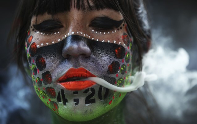 Ana Mendez Casteñeda smokes marijuana during “Fumaton 420” outside the national Senate in Mexico City, Tuesday, April 20, 2021. The demonstrators are calling for the legalization of marijuana. (Photo by Marco Ugarte/AP Photo)