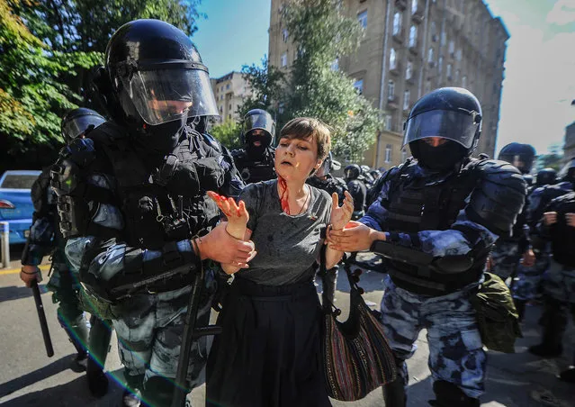 An injured protester is taken away by Moscow riot police on July 27, 2019. Police in Moscow detained more than 1,300 people in a day of protests against alleged irregularities in the run-up to local elections. The United States, the European Union, and human rights groups denounced what they called the "disproportionate” and “indiscriminate” use of force against the demonstrators. (Photo by Anton Sergienko/Radio Free Europe/Radio Liberty)