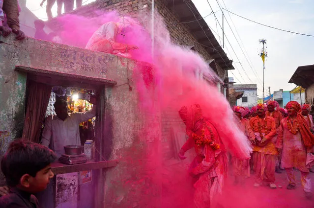 Indian villagers throw coloured powder over others during Lathmar Holi celebrations in the village of Jaab in Kosi Kalan, in Mathura district of Uttar Pradesh state, on March 14, 2017. Holi, also called the Festival of Colours, is a popular Hindu spring festival observed in India at the end of the winter season on the last full moon day of the lunar month. (Photo by Chandan Khanna/AFP Photo)