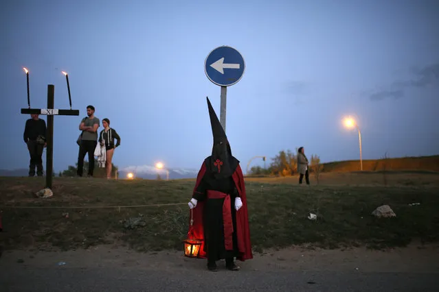 A hooded penitent from “Jesus con la Cruz a Cuestas” brotherhood holds a lantern with a candle as taking part in a traditional annual Holy Week procession in Segovia, Spain, Thursday, April 13, 2017. Hundreds of processions take place throughout Spain during the Easter Holy Week. (Photo by Francisco Seco/AP Photo)