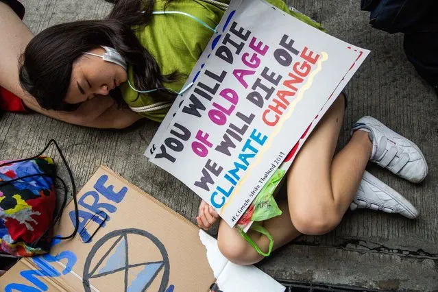 Thai people take part in a “die-in”, where strikers lie on the ground and pretend to die, symbolising the impact of climate change in front of the Ministry of Natural Resources and Environment on September 20, 2019 in Bangkok, Thailand. Hundreds of Thai students, adults and foreigners joined together on Friday as part of a global mass day to demand action on climate change. The movement was inspired by Swedish teenager and climate activist, Greta Thunberg. Climate Change Bangkok delivered an open letter to the Ministery of Natural Resources demanding the government declare a climate emergency and commit to complete the phasing out of coal. (Photo by Lauren DeCicca/Getty Images)