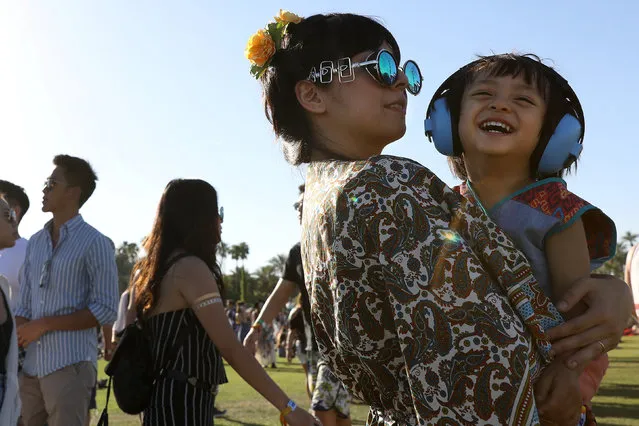 A child basks in the knowledge that she cannot hear the sound of EDM and cackling celebrities on the opening day of the Coachella Valley Music and Arts Festival on April 15, 2017 in Indio, California. (Photo by Carlo Allegri/Reuters)