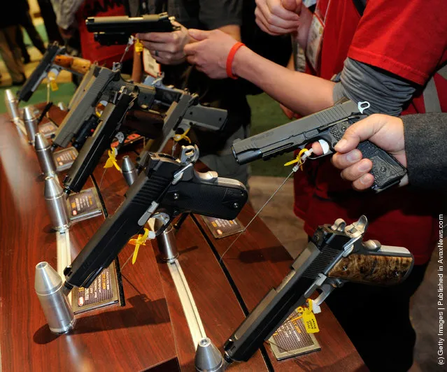 Attendees try out Sig Sauer 1911 model pistols at the Sig Sauer booth