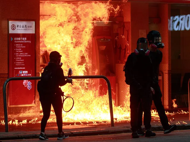 Protesters burn Bank of China's ATM with a petrol bomb in Hong Kong, China on October 1, 2019. (Photo by Kevin On Man Lee/Penta Press/Rex Features/Shutterstock)