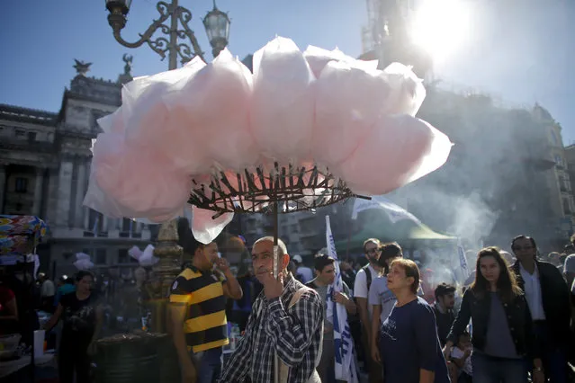 A man sells cotton candy during a May Day demonstration outside Congress in Buenos Aires, Argentina, Monday, May 1, 2017. (Photo by Victor R. Caivano/AP Photo)