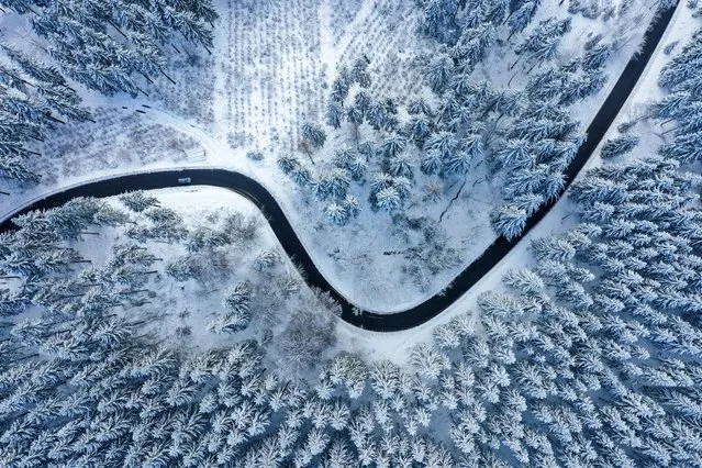 An aerial view shows a snow covered landscape on a sunny winter day of January 6, 2022, near Winterberg, western Germany. (Photo by Ina Fassbender/AFP Photo)