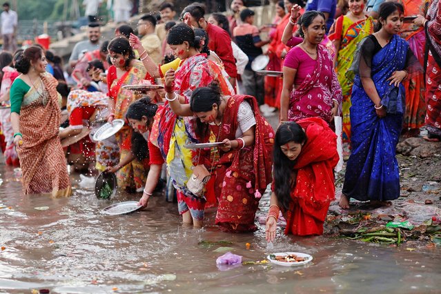 Bangladeshi Hindu devotees release oil lamps to the Buriganga river as they observe Bipodtarini or Bipodnashini puja in Dhaka, Bangladesh on July 9, 2024. (Photo by Mohammad Ponir Hossain/Reuters)