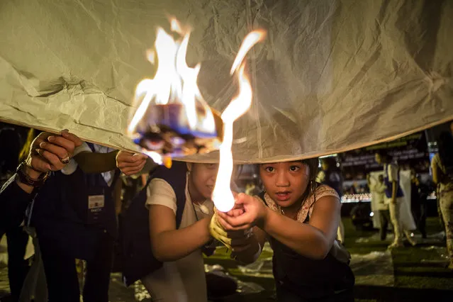 A Buddhist follower girl light a  lantern as they prepare release lanterns into the air on Borobudur temple during celebrations for Vesak Day on May 10, 2017 in Magelang, Central Java, Indonesia. Buddhists in Indonesia celebrate Vesak at the Borobudur temple annually, which makes it the most visited tourist attraction in Indonesia. It is observed during the full moon in May or June, with the ceremony centered at three Buddhist temples by walking from Mendut to Pawon and ending at Borobudur. The stages of life of Buddhism's founder, Gautama Buddha, which are celebrated at Vesak are his birth, enlightenment to Nirvana, and his passing (Parinirvana). (Photo by Ulet Ifansasti/Getty Images)