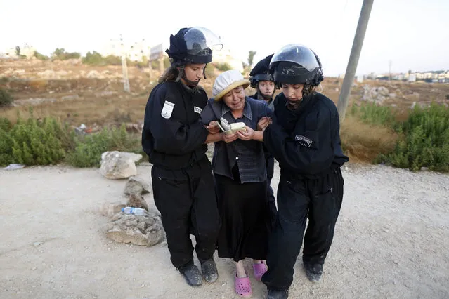 Female Israeli security forces drag away an Israeli settler woman during the evacuation of a 24 housing units illegal building site where settlers had barricaded at the Jewish settlement of Beit El, near the West Bank town of Ramallah, early 28 July 2015. Israel's Supreme Court earlier had ruled to demolish the 24 housing units in the settlement claiming they were illegally built on private Palestinian land. (Photo by Abir Sultan/EPA)