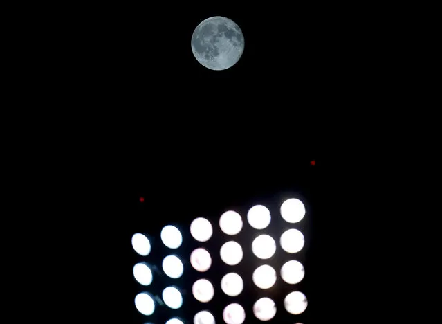 A blue moon rises behind the US Cellular Field lights during the eighth inning of a baseball game between the Chicago White Sox and the New York Yankees in Chicago, Friday, July 31, 2015. A blue moon happens when the moon rises in its full stage twice during the same month. (Photo by Jeff Haynes/AP Photo)