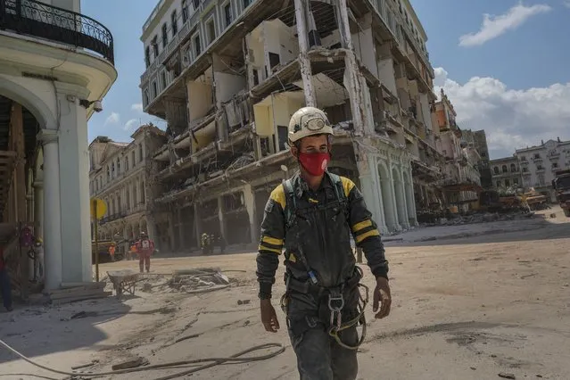 A rescue worker walks away from the destroyed five-star Hotel Saratoga after searching through the rubble days after a deadly explosion in Old Havana, Cuba, Tuesday, May 10, 2022. An apparent gas leak ignited on Friday, May 6. (Photo by Ramon Espinosa/AP Photo)