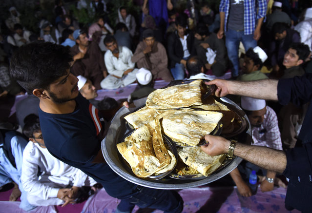 Afghan Muslims distribute food as others break their fast during the Islamic holy month of Ramadan at the Wazir Akbar Khan Mosque in Kabul on June 13, 2016. Muslims throughout the world are marking the month of Ramadan, the holiest month in the Islamic calendar during which devotees fast from dawn till dusk. (Photo by Wakil Kohsar/AFP Photo)