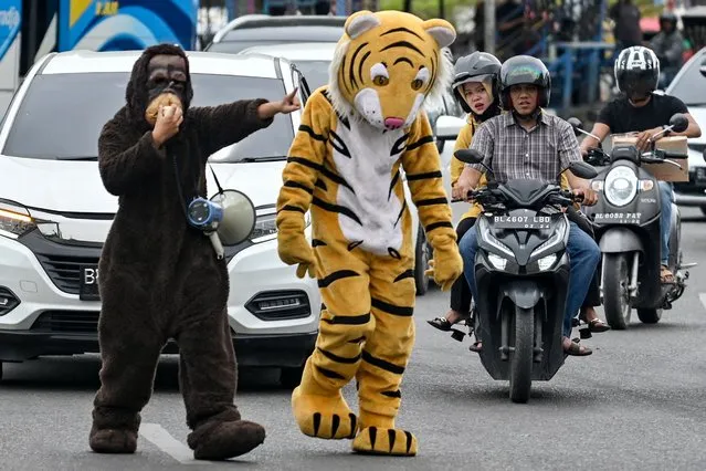University students wearing tiger and orangutan costumes take part in a rally for World Environment Day, marked annually on June 5, in Banda Aceh on June 7, 2022. (Photo by Chaideer Mahyuddin/AFP Photo)