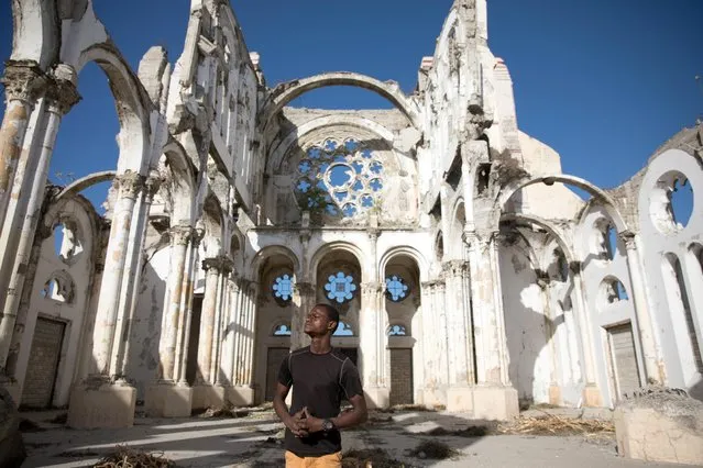 Paul Christandro poses for a picture inside of Notre Dame de l'Assomption Cathedral (Our Lady of the Assumption), destroyed in the 2010 earthquake, in Port-au-Prince, Haiti on January 10, 2020. Every morning as the sun rises over the dusty, overgrown ruins of the Haitian capital's iconic cathedral, Paul Christandro, who lived nearby all his life, thinks about the day ten years ago when he watched it come down, killing his friends. (Photo by Valerie Baeriswyl/Reuters)