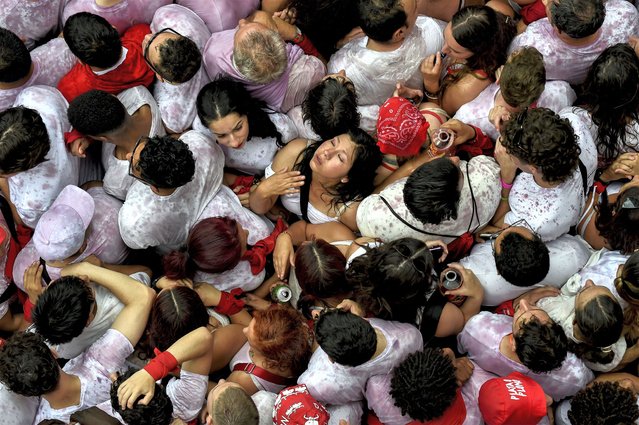 Participants gather during the “Chupinazo” (start rocket) opening ceremony to mark the kick-off of the San Fermin bull Festival outside the Town Hall of Pamplona in northern Spain on July 6, 2023. Thousands of people every year attend the week-long festival and its famous “encierros'” six bulls are released at 8:00 a.m. evey day to run from their corral to the bullring through the narrow streets of the old town over an 850 meters (yard) course while runners ahead of them try to stay close to the bulls without falling over or being gored. (Photo by Miguel Riopa/AFP Photo)