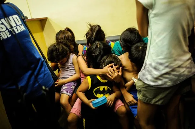 Social workers and police round up minors at night during curfew, June 8, 2016, in Manila, Philippines. (Photo by Dondi Tawatao/Getty Images)