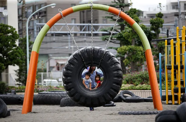 Children ride on a swing made from a tyre at Nishi Rokugo Park, also known as Tyre Park, in Ota-Ku, Tokyo, Japan on August 17, 2017. The park features attractions made from thousands of recycled ttyres. (Photo by Kim Kyung-Hoon/Reuters)
