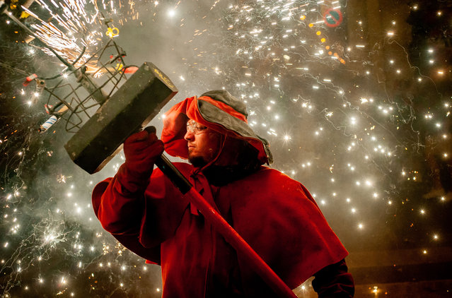 A devil makes explode pyrotechnics during a correfoc for the celebration of the Gracia Quarter Festival (Festes de Gracia) in Barcelona, Spain on August 21, 2023. Correfocs, an old Catalan tradition where people dressed as devils blow up firecrackers and flares, take part every August in the celebrations for the Gracia Quarter Summer Festival in Barcelona. (Photo by Jordi Boixareu/ZUMA Press Wire/Rex Features/Shutterstock)