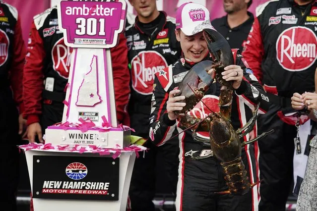 Christopher Bell holds up a giant lobster while celebrating after winning a NASCAR Cup Series auto race at the New Hampshire Motor Speedway, Sunday, July 17, 2022, in Loudon, N.H. (Photo by Charles Krupa/AP Photo)