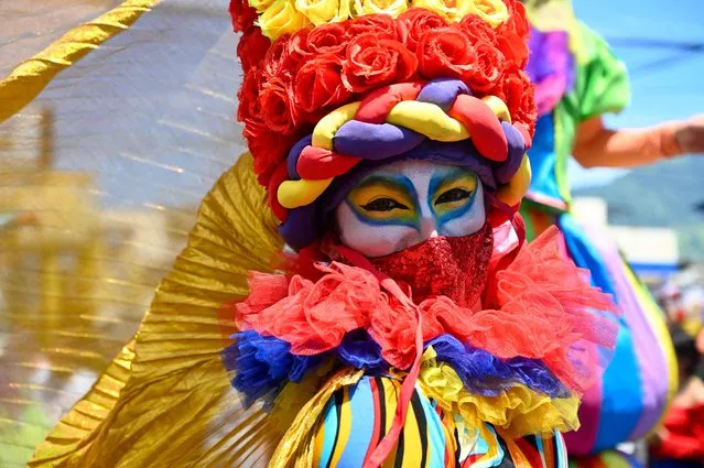 A clown marches during the traditional mail parade, which marks the beginning of the festivity in honour of the Divine Saviour of the World in San Salvador, on August 1, 2022. (Photo by Sthanly Estrada/AFP Photo)