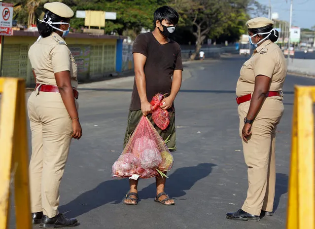 A man carrying vegetables is stopped by police at a barricade on a road during a 21-day nationwide lockdown to limit the spreading of coronavirus disease (COVID-19) in Chennai, India, March 25, 2020. (Photo by P. Ravikumar/Reuters)