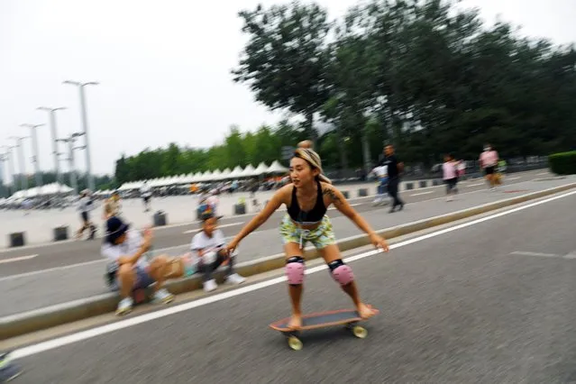 Sui Zhuoyan, 32, a member of Beijing Girls Surfskating Community, rides a skateboard barefoot during a free weekly training session, outside the National Sports Stadium in Beijing, China June 19, 2022. (Photo by Tingshu Wang/Reuters)