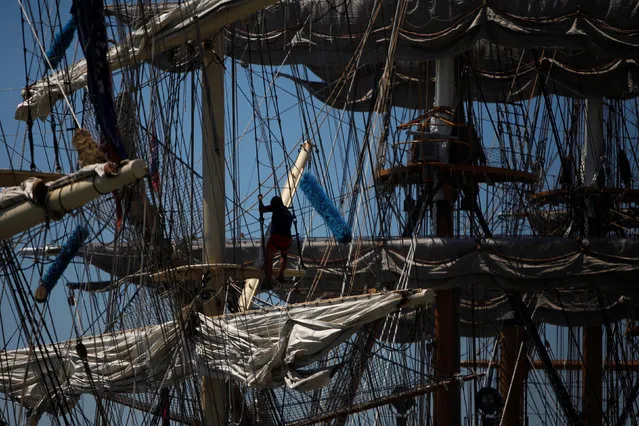 Crew members prepare a ship before the beginning of the Tall Ships Races 2016 parade, in Lisbon, Portugal, July 25, 2016. (Photo by Pedro Nunes/Reuters)