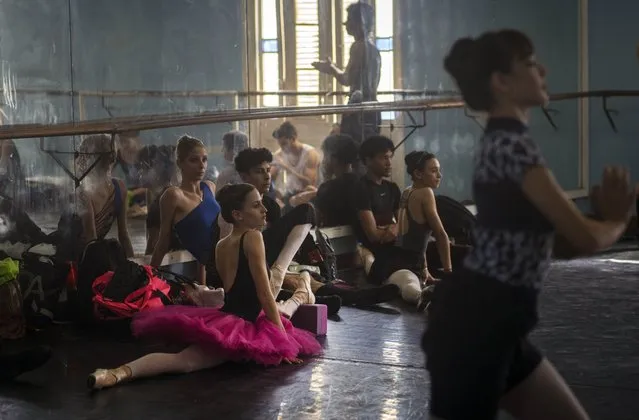 Members of the national ballet of Cuba stretch while they watch a practice directed by Viengsay Valdes in Havana, Cuba, Thursday, December 12, 2019. Valdes, the new head of Cuba's legendary National Ballet, says she hopes to renew the institution after the death of long-time director Alicia Alonso by introducing new choreography and appearances by dancers who have emigrated to other companies. (Photo by Ramon Espinosa/AP Photo)