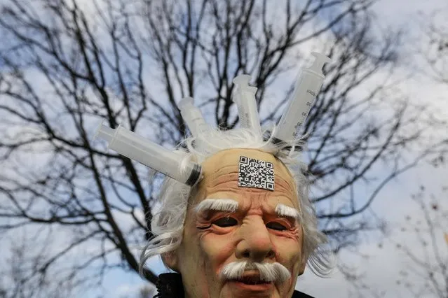 A man wears a mask riddled with syringes during a protest in front of the headquarters of the Romanian Parliament in Bucharest, December 21, 2021, amid the novel coronavirus / Covid-19 pandemic. A couple of thousands of people gather in a protest at the call of nationalist parliamentary party A.U.R. (the Alliace for the Unity of Romanians) against a draft law meant to introduce the Covid-19 “green pass” for the work place. (Photo by Octav Ganea/Inquam Photos via Reuters)
