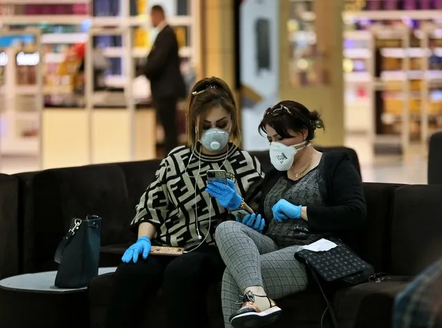 Passengers wear protective masks while waiting for their plane in Baghdad Airport, Iraq, Wednesday, March 4, 2020. From religion to sports, countries were taking drastic and increasingly visible measures to curb the new coronavirus that first emerged in China and was spreading quickly through Europe, the Mideast and the Americas. (Photo by Hadi Mizban/AP Photo)