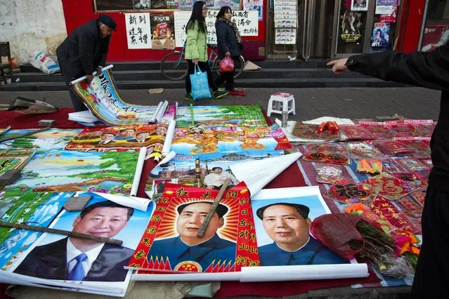 In this February 5, 2015 file photo, vendors sell posters of Chinese President Xi Jinping, left, and Communist Party founder Mao Zedong, center and right, on a street of Gujiao in northern China's Shanxi province. Authorities ordered a state broadcaster to punish a popular TV celebrity for insulting Mao at a private dinner, state media reported. (Photo by Ng Han Guan/AP Photo)
