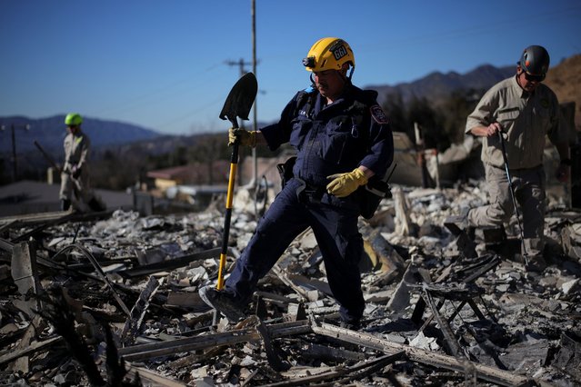 A search and rescue worker investigates the charred remains of a house, as the Eaton Fire continues, in Altadena, Los Angeles County, California, on January 15, 2025. (Photo by Daniel Cole/Reuters)
