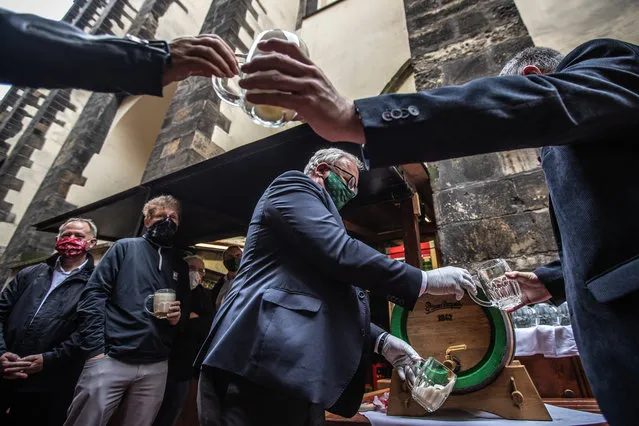 Employees of a restaurant tap beer during the official reopening of a restaurant garden in the centre of Prague, Czech Republic, 11 May 2020. Restaurants and cafes across the country are allowed to open their outside seatings from 11 May 2020 as next wave of Czech government?s easing the restrictive measures declared to quell the spread of the pandemic COVID-19 disease caused by the SARS-CoV-2 coronavirus. (Photo by Martin Divisek/EPA/EFE)