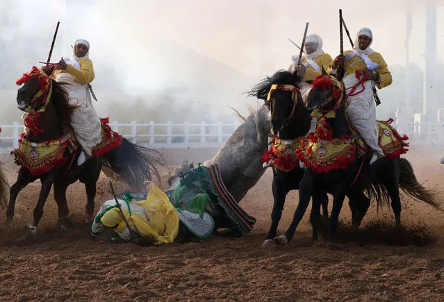 A traditional Moroccan knight falls off his horse in an equestrian show during the Festival of Tbourida, a competition between the Moroccan tribes, in Al-Jadidah, Morocco, 18 October 2017. Tbourida is a traditional exhibition of horsemanship in the Maghreb performed during cultural festivals and to close Maghrebi wedding celebrations. The performance consists of a group of horse riders, all wearing traditional clothes, who charge along a straight path at the same speed so as to form a line, the pickup speed and then at the end of the charge, fire into the sky using old muskets or muzzle-loading rifle. (Photo by Nabil Mounzer/EPA/EFE)