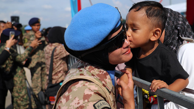 A child kisses a Malaysian United Nations (UN) peacekeeping officer during a ceremony before leaving for Lebanon at the air force base in Subang outside Kuala Lumpur, Malaysia, 06 November 2024. The first group of the Malaysian Battalion (Malbatt 850-12) from the Malaysian Armed Forces and Royal Brunei Military Force will leave for Lebanon to participate in the United Nations Interim Force in Lebanon (UNIFIL). (Photo by Fazry Ismail/EPA)
