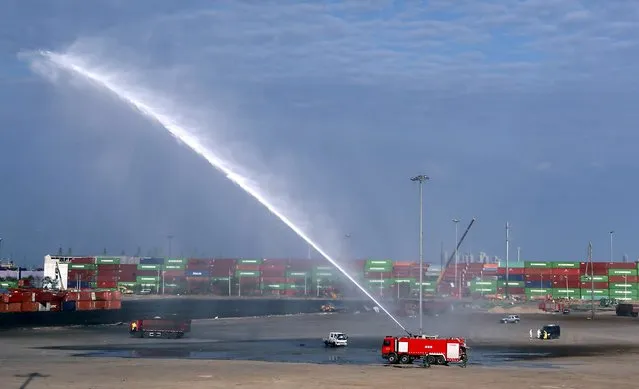 A firefighter truck sprays liquid as workers clean up the centre of the explosions on August 12 at Binhai new district in Tianjin, China, September 11, 2015. The clean-up process of the centre of the blasts, that killed 160 people, is finished on Friday, after which the environmental protection procedures will initiate under the guidance of government environmental protecting bureaus and experts, local media reported. (Photo by Reuters/Stringer)