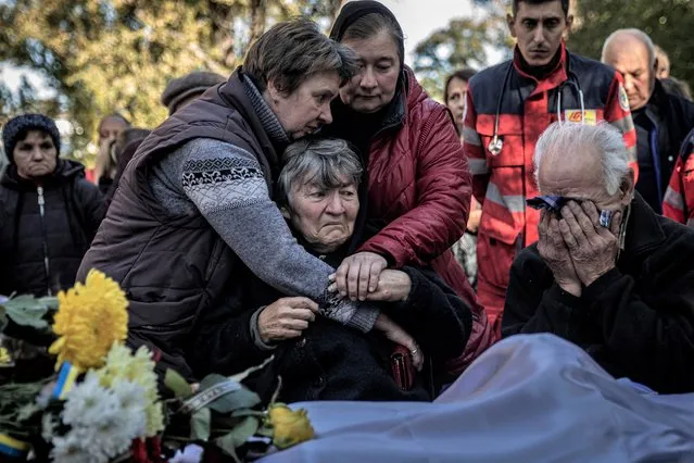 The parents of a Ukrainian soldier killed by shrapnel during fighting in the Donetsk province grieve as he is laid to rest in Kamianske, Ukraine on October 18, 2022. Ukrainians were trying to conserve energy nationwide as President Volodymyr Zelenskyy warned on Tuesday that Russian attacks over the past eight days had destroyed 30% of Ukraine's power stations. (Finbarr O'Reilly/The New York Times)