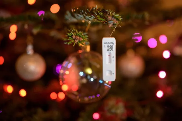 This photograph taken on December 24, 2021 shows a negative SARS-CoV-2 rapid antigen test used to detect the Covid-19 coronavirus hanging on a Christmas tree in Lausanne. (Photo by Fabrice Coffrini/AFP Photo)