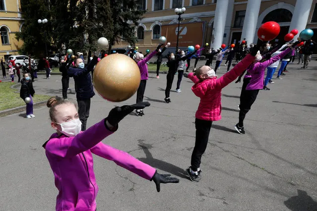 Students of rhythmic gymnastics school wearing protective face masks and gloves take part in an open-air training session entitled “Save Deriugina school” to draw attention to the closing of their training facility due to poor condition of the building, amid the coronavirus disease (COVID-19) outbreak in Kiev, Ukraine on June 1, 2020. (Photo by Valentyn Ogirenko/Reuters)