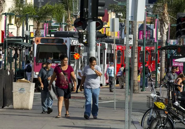 People walk from a trolley transit hub that traffics people to and from the border in the in San Ysidro, California September 2, 2015.  Picture taken September 2, 2015. (Photo by Mike Blake/Reuters)