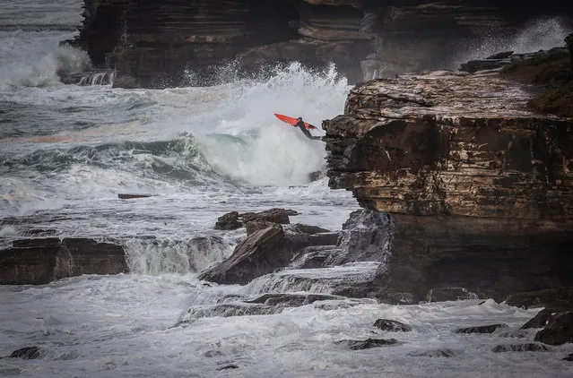 A surfer jumps off rocks into the surf on July 14, 2020 at Warriewood Beach in Sydney, Australia. The Bureau of Meteorology has issued a severe weather warning for Sydney and large parts of coastal NSW, with damaging winds and surf expected across the state. (Photo by David Gray/Getty Images)